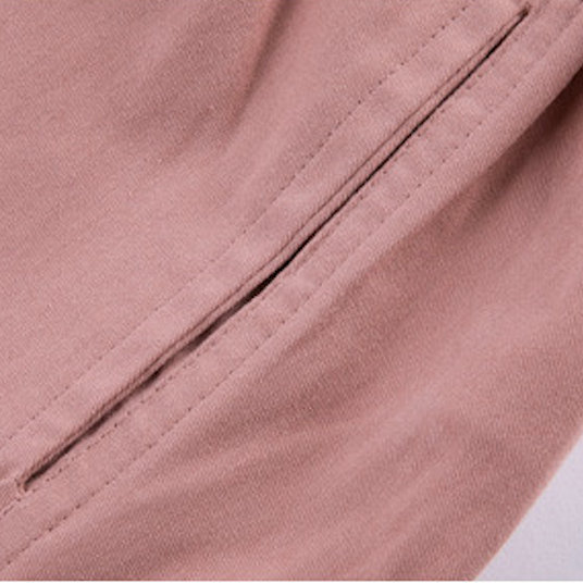 Un gros plan sur une poche cargo rose sur un pantalon cargo coupe droite resserré aux chevilles pour fille. Ajoutez une touche de modernité à la garde-robe de votre fille avec ce pantalon rose taille haute, doté d'un élastique à la taille pour un ajustement parfait. Les poches cargo ajoutent une touche fonctionnelle. Disponible dans différentes tailles.