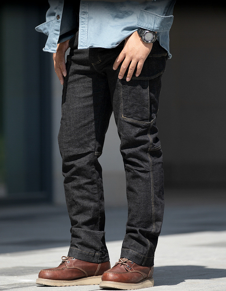 Un homme portant un jean noir et une montre, les mains dans les poches. Les détails du jean cargo ajusté coupe droite - Noir - Homme de Cargo District.