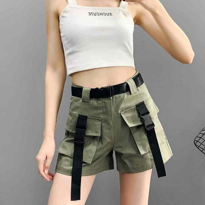 Une femme portant un short cargo kaki avec ceinture et lanières à clip. Un look urbain et féminin avec taille haute et ample, poches cargo et ceinture noire pour accentuer la taille. Disponible du S au 2XL.