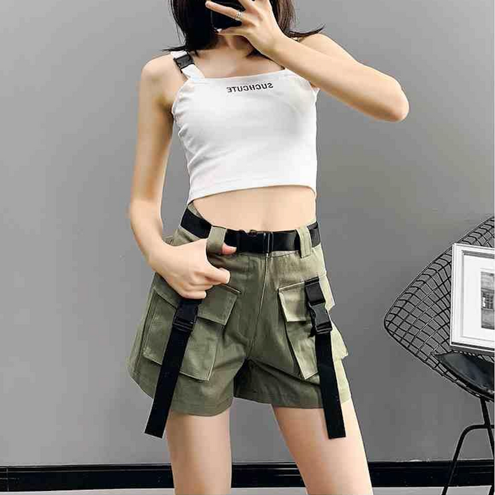 Une femme prenant un selfie, portant un short cargo kaki avec ceinture à lanières à clip. Le short est ample, taille haute et comporte des poches cargo ornées de lanières à clip pour un look urbain et féminin. Disponible du S au 2XL. Vêtement durable et confortable en coton et polyester. Cargo District - site de vente de vêtements de style cargo.