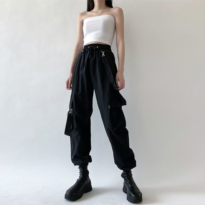 Une femme portant un pantalon noir avec un haut blanc, des bretelles amovibles et des poches cargo. Pantalon cargo sangles bretelles amovibles - Noir - Femme.