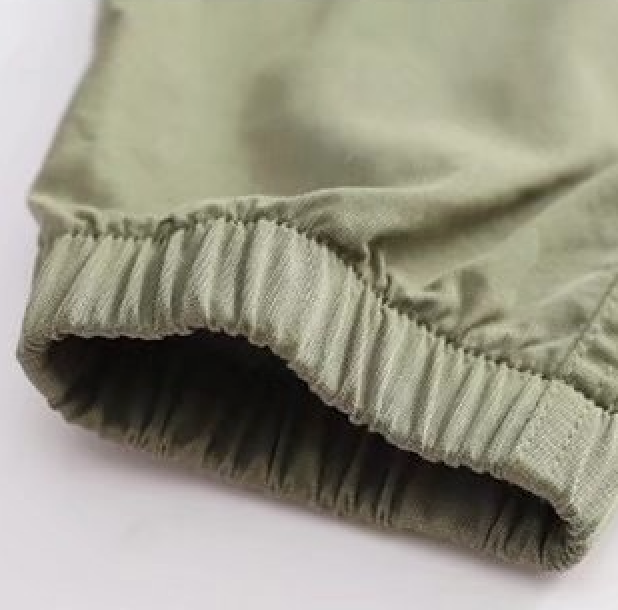 Un gros plan sur un pantalon cargo jogger large kaki pour garçon avec des poches latérales pratiques. Disponible du 110 au 160 cm. Coupe resserrée aux chevilles et taille élastique pour un ajustement parfait et un confort maximal. Matières : coton et polyester.