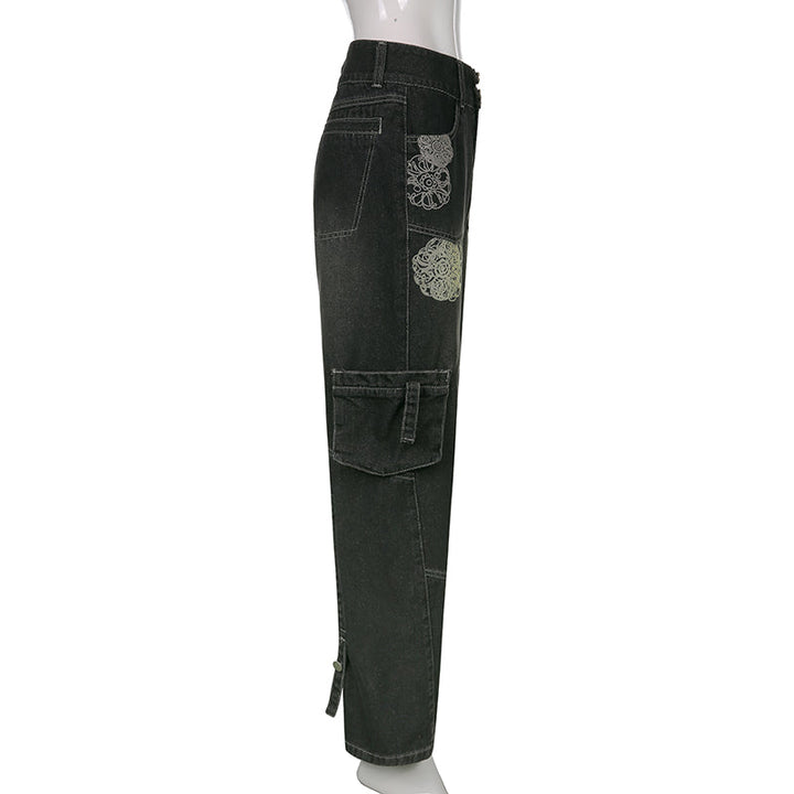 Un pantalon cargo baggy gris avec des rosaces blanches - Femme. Modèle taille basse et coupe baggy pour un look décontracté et stylé. Poches cargo latérales pratiques. Disponible du S au L.