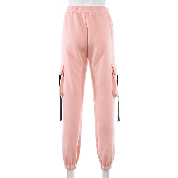 Un pantalon cargo rose avec lanières noires pour femme, taille haute et coupe jogger. Confortable et flatteur, disponible du S au L.