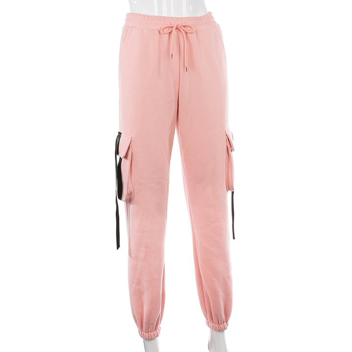 Un pantalon cargo rose avec lanières noires pour femme, taille haute et coupe jogger. Confortable et flatteur, disponible du S au L.
