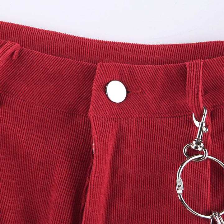 Un pantalon cargo baggy en velours côtelé rouge pour femme avec des chaînes ajoutées sur le côté. Taille haute, élastique aux chevilles. Disponible en tailles S à L.