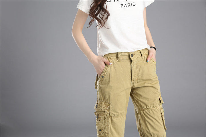 Une femme portant un short cargo long coupe droite beige avec des poches cargo latérales. Un style urbain simple et audacieux pour un look décontracté. Disponible en tailles US 28 à 38. Fabriqué en coton pour un confort optimal.