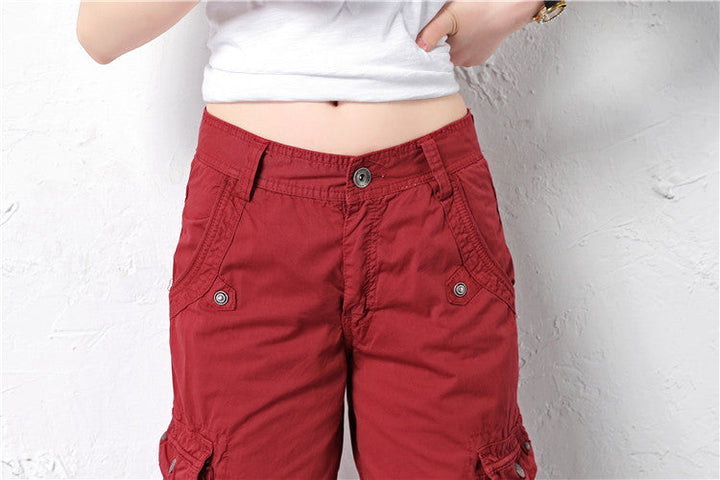 Une femme porte un Short cargo long coupe droite rouge bordeaux avec des poches cargo latérales. Ce short en coton est confortable et durable. Disponible en tailles US 28 à 38.