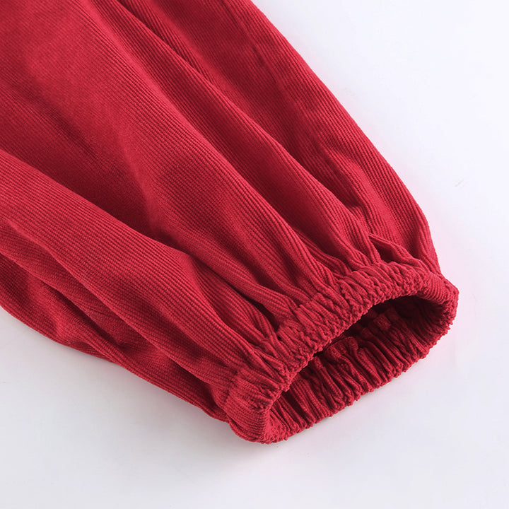 Un pantalon cargo baggy en velours côtelé pour femme avec une chaîne ajoutée sur le côté. Taille haute, ajustement parfait grâce à l'élastique aux chevilles. Disponible en rouge.