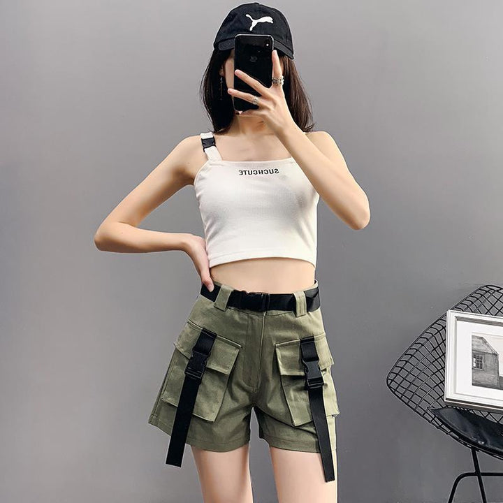 Une femme prenant un selfie avec un short cargo kaki à ceinture lanières à clip pour Femme de la marque Cargo District. Le short est taille haute et ample, avec des poches cargo ornées de lanières à clip pour une touche tendance. Disponible du S au 2XL.