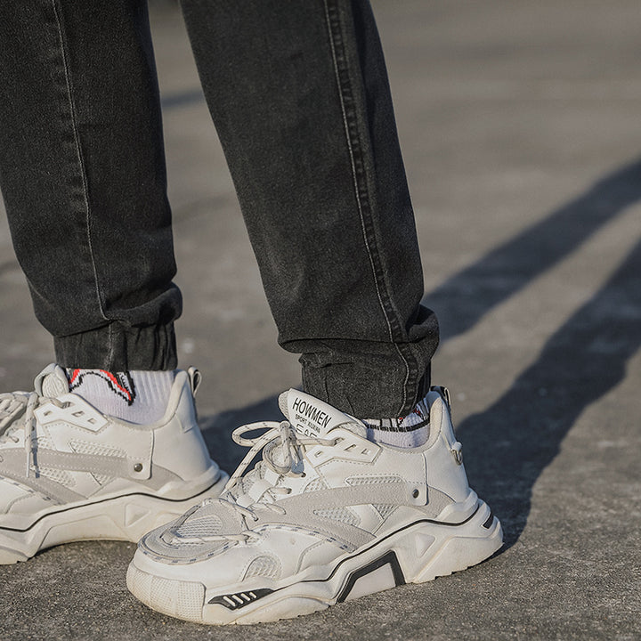 Un homme portant des baskets blanches - Jean cargo coupe droite resserré aux chevilles - Noir - Homme.