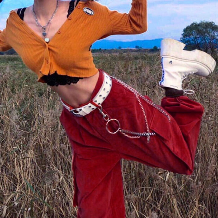 Femme dans un champ portant un Pantalon cargo baggy chaînes velours cotelé rouge. Coupe taille haute, finition velours côtelé. Tailles S à L.