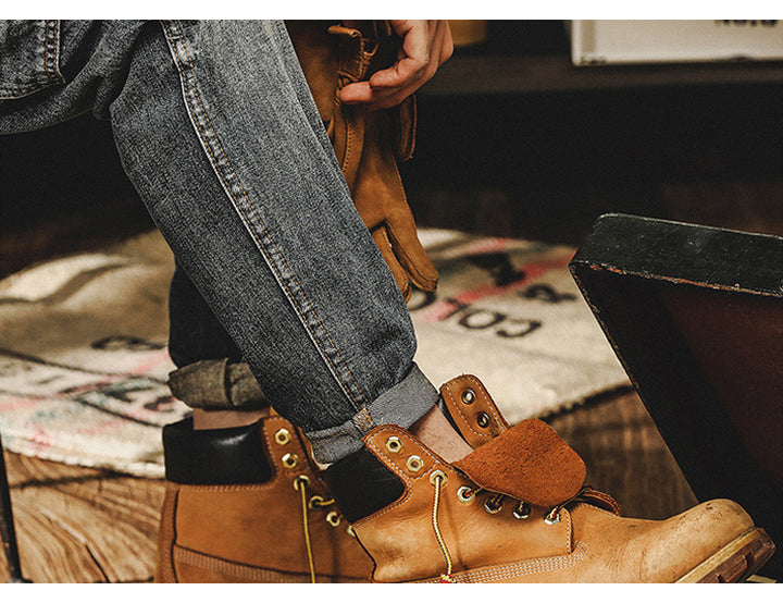 Un homme portant des bottes et un jean cargo délavé coupe droite - Bleu. Les bottes ajoutent une touche tendance à sa tenue. Disponible en tailles US du 28 au 40. Conçu en 100% coton pour un confort durable.