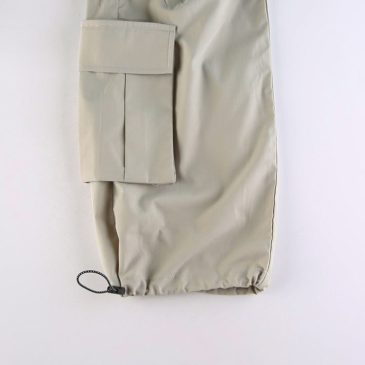 Un gros plan d'un pantalon cargo gris pour femme avec des poches latérales spacieuses et une taille basse.