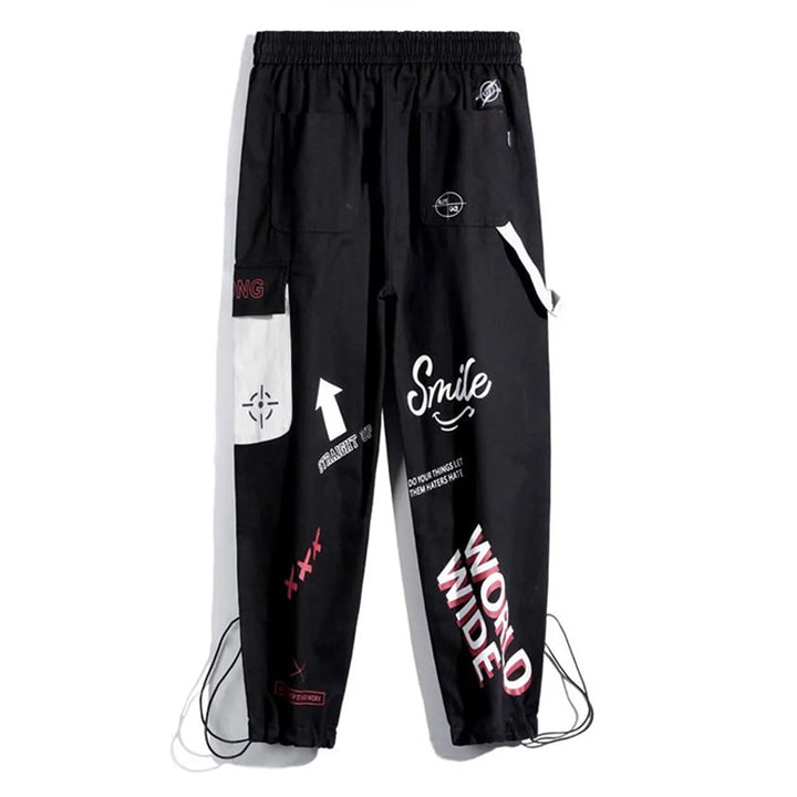 Pantalon cargo jogger noir à motif pour femme - Coupe jogger taille haute avec motifs blancs et roses. Poche latérale et lanière gris clair ajoutant une touche d'originalité. Confection en coton pour un confort optimal. Disponible du S au 3XL.