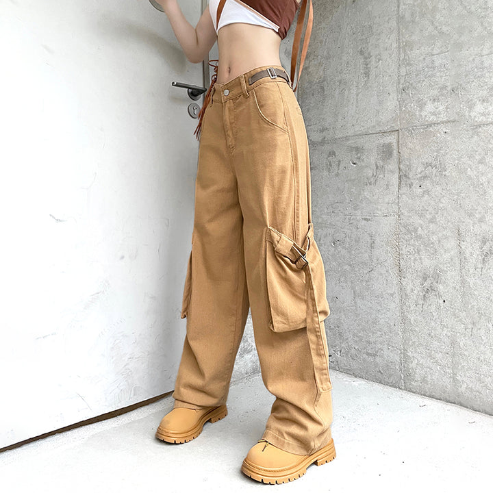 Une femme portant un jean cargo baggy camel avec des lanières aux poches. Ce jean taille haute offre un look urbain tendance. Disponible du S au L.