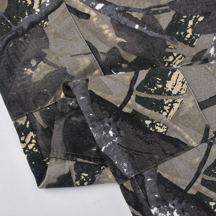 Un pantalon cargo taille haute imprimé feuilles pour femme, en tissu camouflage. Silhouette ajustée et légèrement évasée. Confortable et tendance street-style. Disponible en tailles S à L.