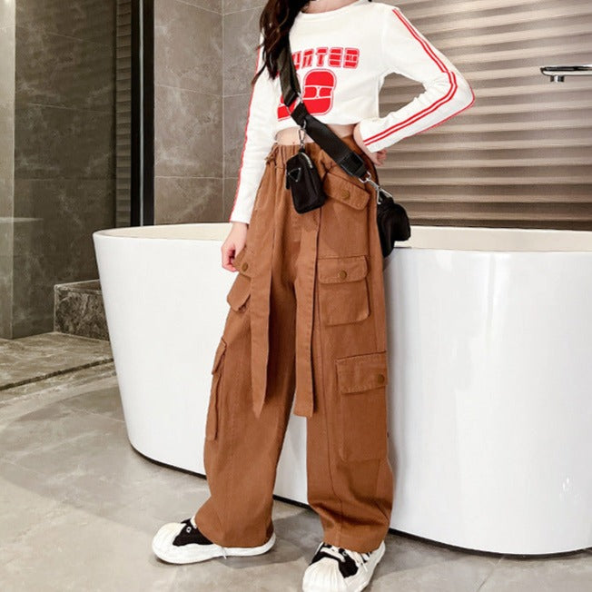 Une femme debout devant une baignoire, porte un Pantalon cargo large taille haute ceinture - Marron - Fille de Cargo District.