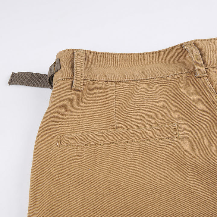 Un gros plan sur un pantalon cargo camel pour femme avec des lanières aux poches. Coupe baggy, taille haute, disponible du S au L. Un look urbain tendance pour votre garde-robe cargo.