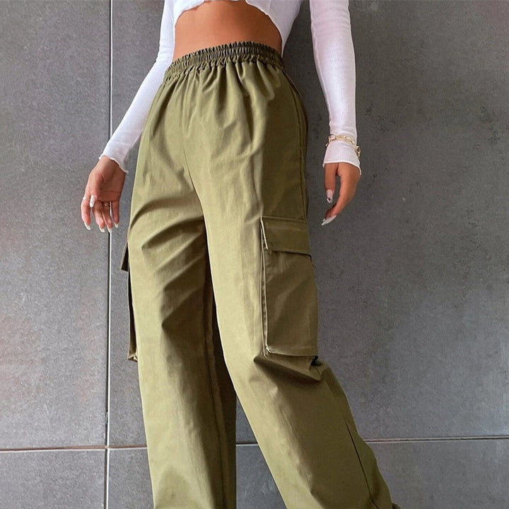 Une femme portant un pantalon cargo baggy kaki avec taille haute et jambes larges. Le pantalon est en polyester léger et durable. Disponible du S au XL. Les multiples poches ajoutent une fonctionnalité à ce pantalon unique. Parfait pour un style streetwear irrésistible.