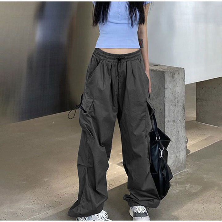 Une personne portant un pantalon cargo baggy léger gris pour femme. Coupe baggy avec élastique à la taille et aux chevilles pour un confort exceptionnel. Poches latérales ajoutant une touche street et féminine. Disponible du S au 3XL.