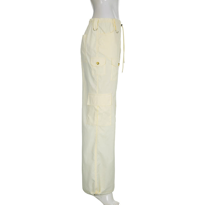 Un pantalon cargo baggy taille basse élastique pour femme en blanc cassé. Fabriqué en polyester et spandex légers, il offre un ajustement confortable grâce à l'élastique à la taille. Son style baggy, accompagné d'un élastique à la cheville, structure la coupe pour un rendu tendance. Disponible du S au L.