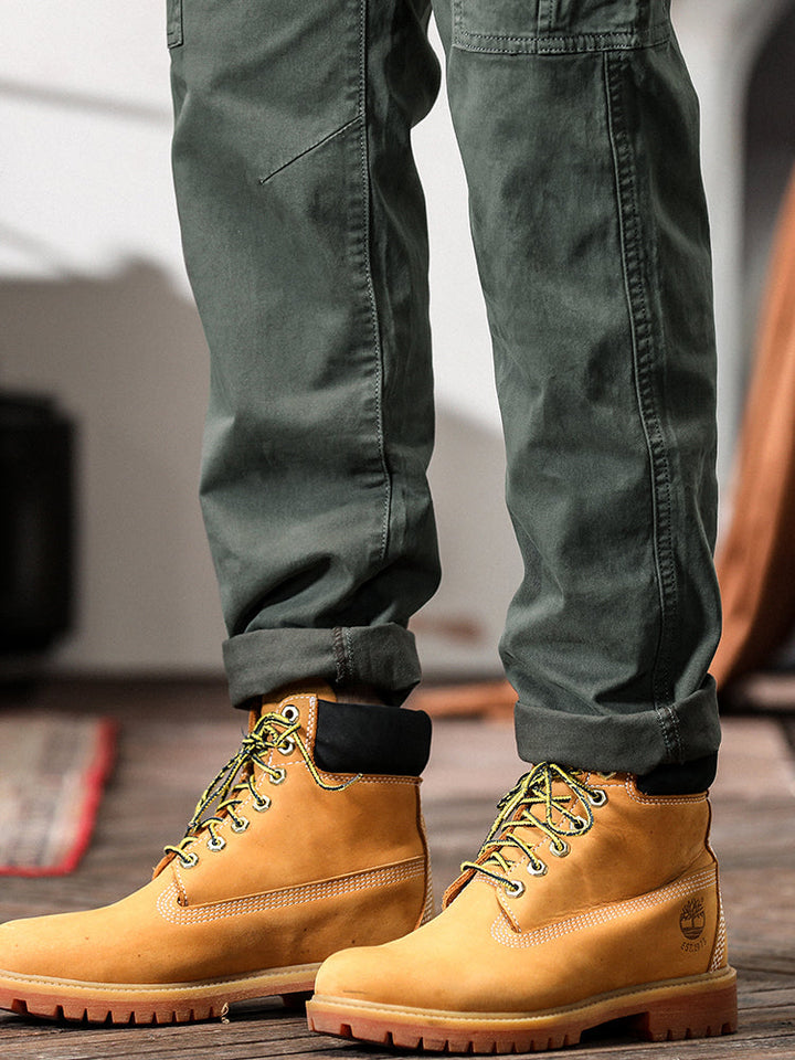 Un homme portant un pantalon cargo gris avec des bottes jaunes.