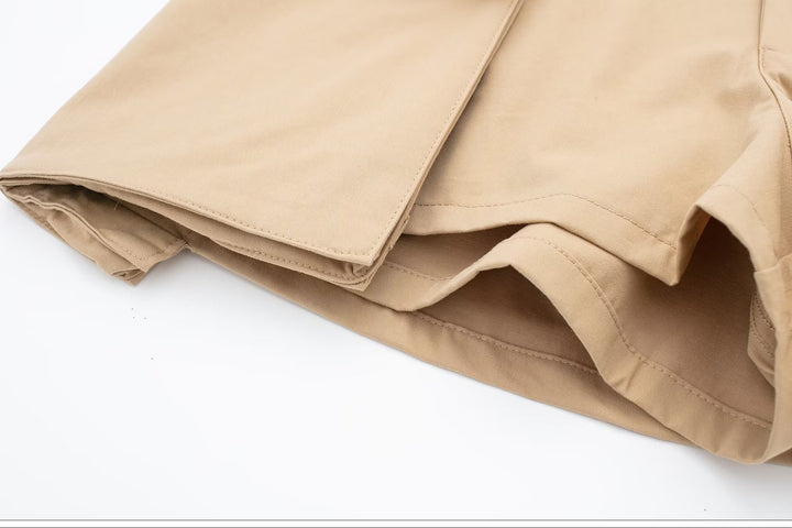 Jupe short cargo beige pour femme, pliée en tissu léger et durable. Élégante mini-jupe évasée à l'avant, avec short intégré. Tailles S à XL. Élastique à la taille pour un ajustement parfait. Poches cargo ajoutant une touche de style unique.