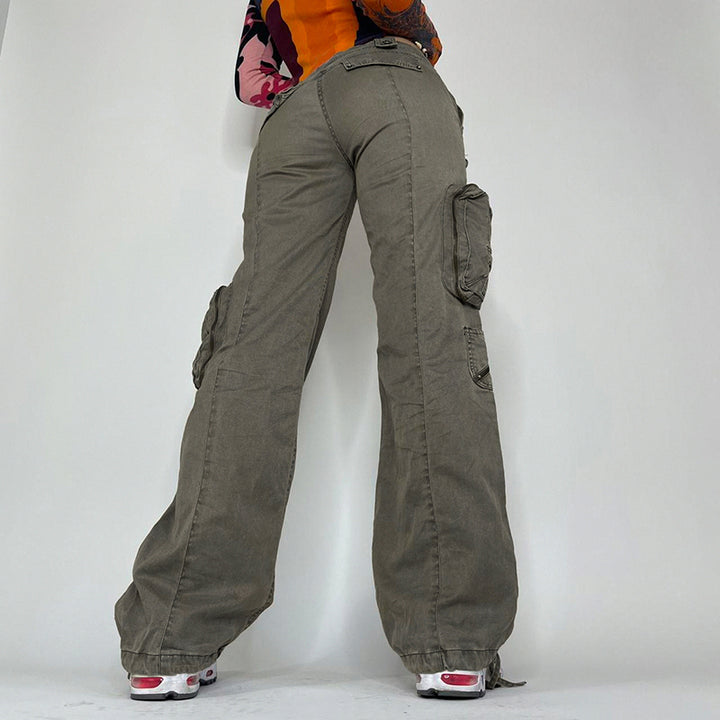 Une femme portant un Pantalon cargo évasé multipoches kaki pour femme. Coupe ajustée à la taille basse, s'évase en bas pour un style moderne. Matières : coton, polyester et spandex pour un confort optimal. Disponible du S au L.