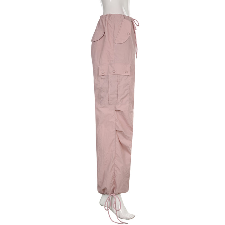 Un mannequin porte un pantalon cargo rose à taille basse, style baggy, avec une jambe large et élastique à la cheville. Disponible du S au L, en polyester et spandex. Confortable et féminin, idéal pour un look urbain.