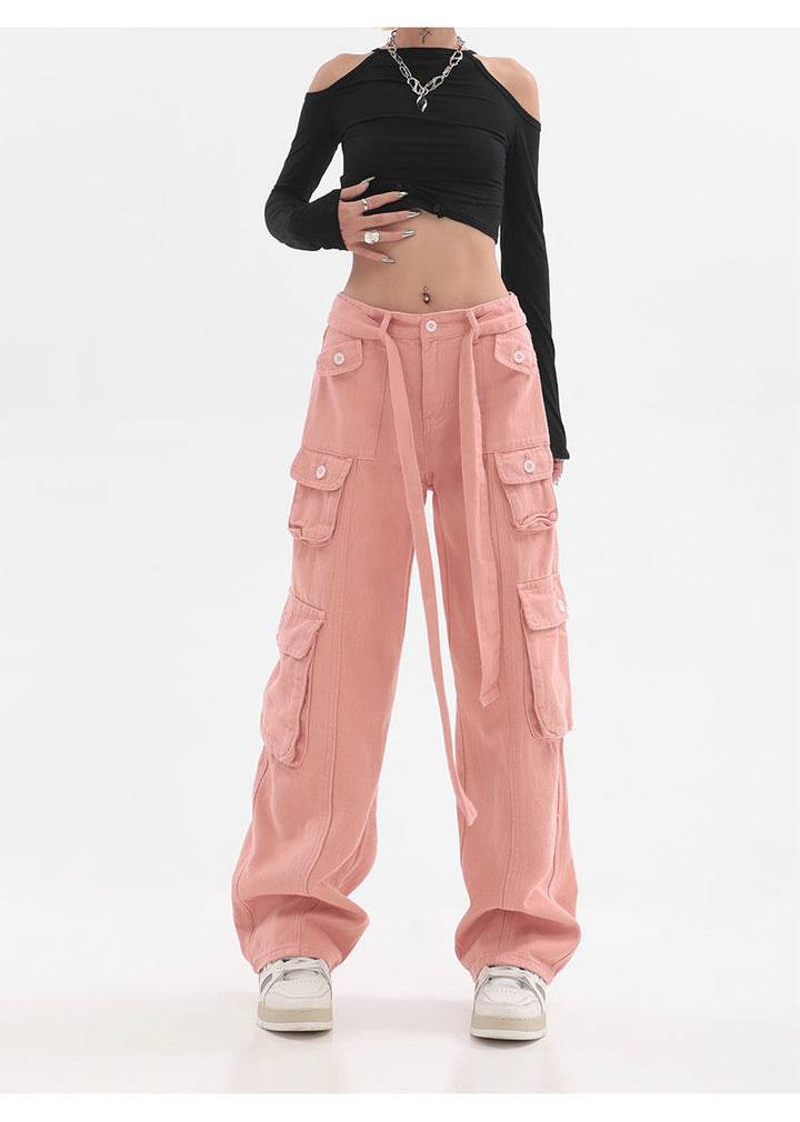 Une femme portant un pantalon rose cargo baggy avec ceinture multipoches - Rose - Femme. Un look tendance et confortable pour toutes les occasions. Disponible du S au XL.