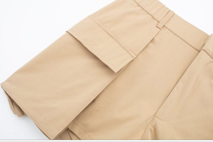 Une vue rapprochée d'un pantalon cargo beige pour femme, avec des poches cargo dépassant légèrement. Un vêtement hybride élégant, alliant la jupe évasée et le confort d'un short. Disponible en tailles S à XL.