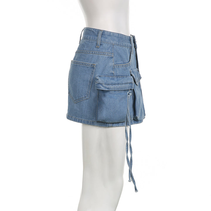 Une mannequin porte une jupe cargo en jean bleu avec plusieurs poches. Coupe droite et silhouette féminine. Disponible en tailles S à L.