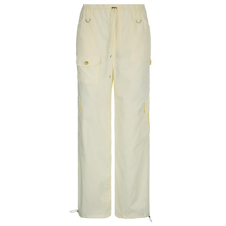 Un pantalon cargo baggy taille basse élastique pour femme avec poches et bouton. Fabriqué en polyester et spandex légers, en blanc cassé. Disponible du S au L.