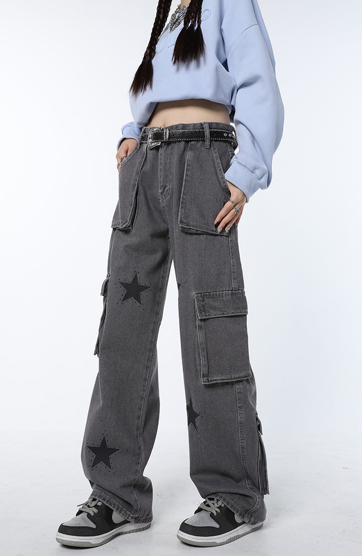 Une personne portant un jean cargo baggy gris avec des étoiles noires.