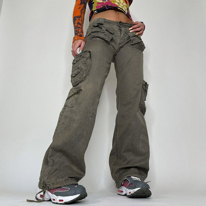 Une femme pose un tee-shirt manches longues multicolore à motif, des baskets et un pantalon cargo taille basse évasée avec nombreuses poches. 