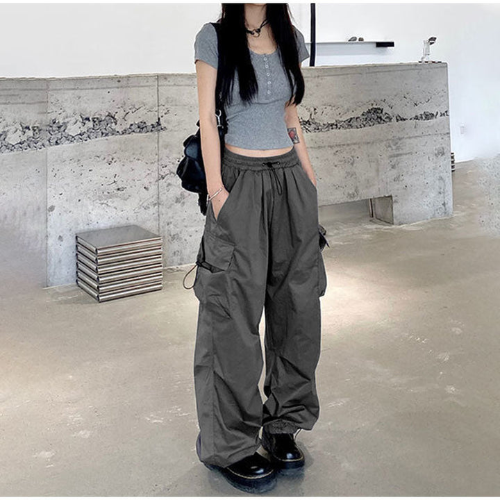 Une femme portant un pantalon gris baggy avec des poches latérales. Le pantalon cargo baggy léger - Gris - Femme de Cargo District.