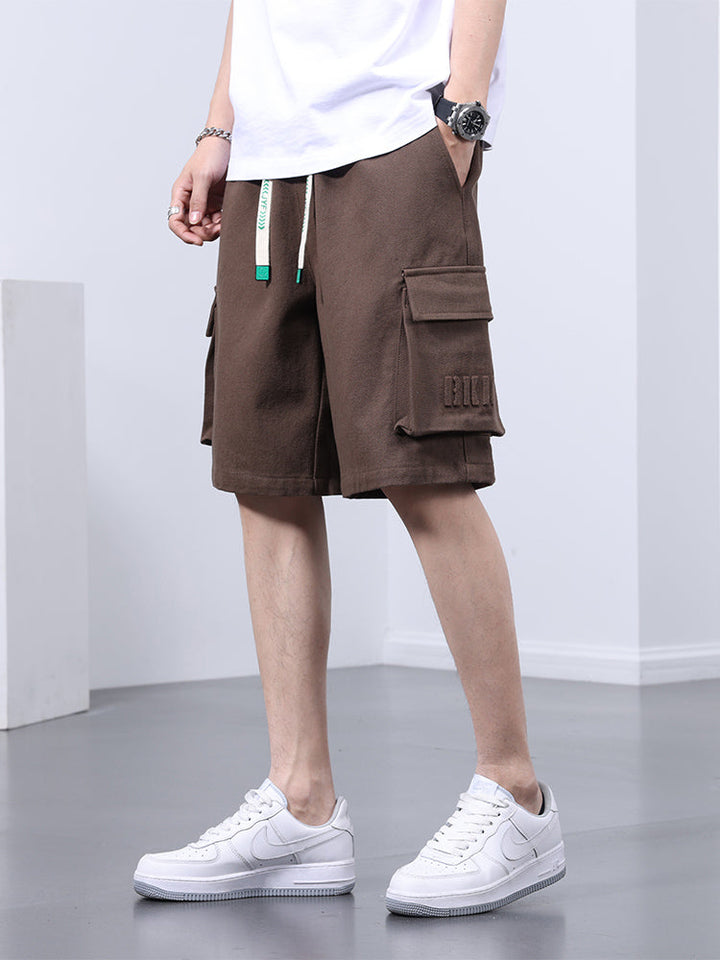 Un homme portant un short cargo marron clair avec des baskets blanches