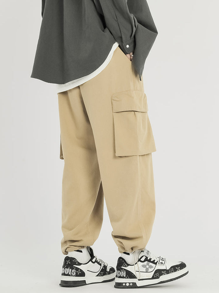 Un homme portant un pantalon cargo baggy en coton beige - Pantalon cargo baggy coton - Beige - Homme.