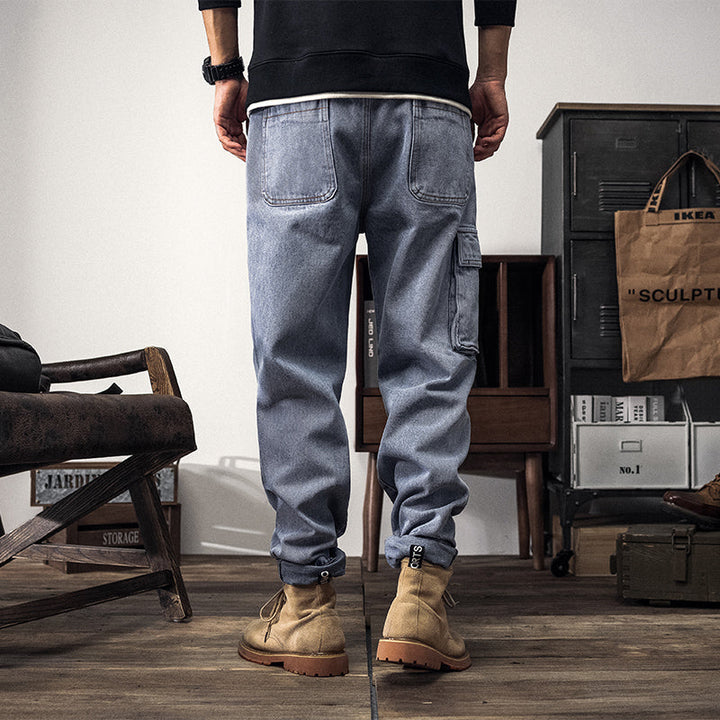 Un homme portant un jean cargo coupe large bleu clair avec des bottes. Les poches latérales cargo ajoutent une touche fonctionnelle et tendance.