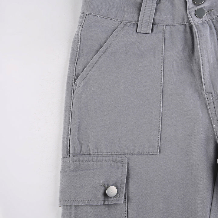 Un pantalon cargo ajusté flare pour femme en gris. Silhouette et courbes mises en valeur avec poches utilitaires. Coupe évasée tendance. Disponible du S au L.