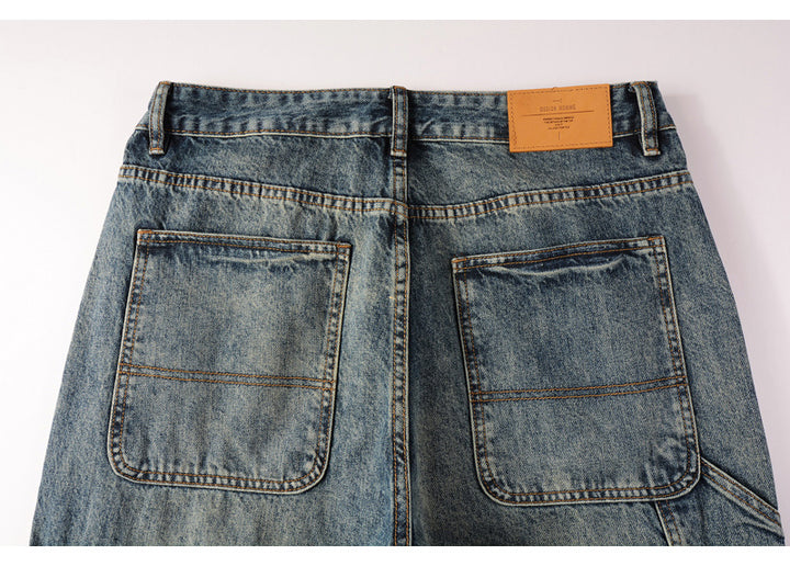 Un gros plan sur une paire de jeans cargo délavés coupe droite pour homme. Les petites poches latérales ajoutent une touche tendance à votre tenue. Disponible en tailles US 28-40. Confectionné en 100% coton pour un confort durable.