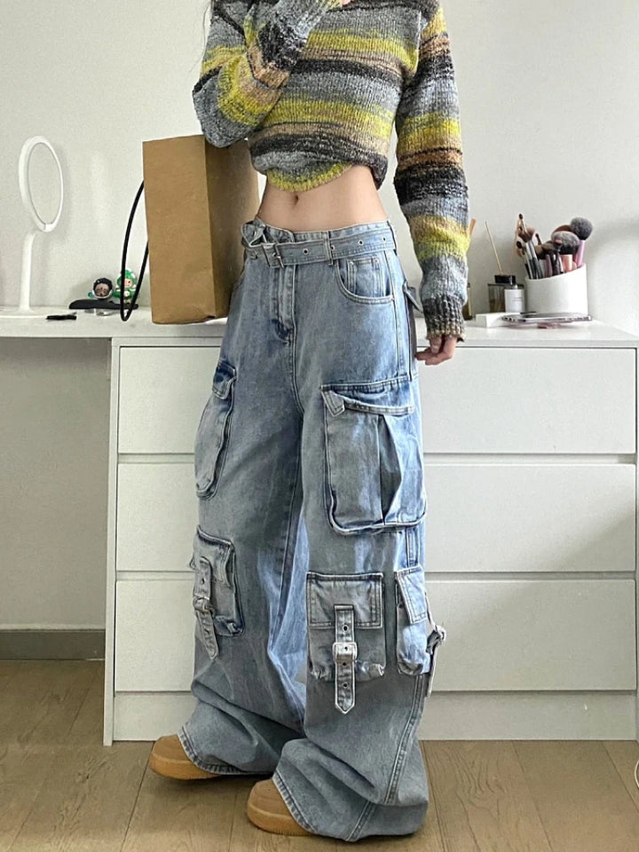 Une femme debout devant une commode blanche avec un jean cargo baggy délavé multipoches - Bleu - Femme.