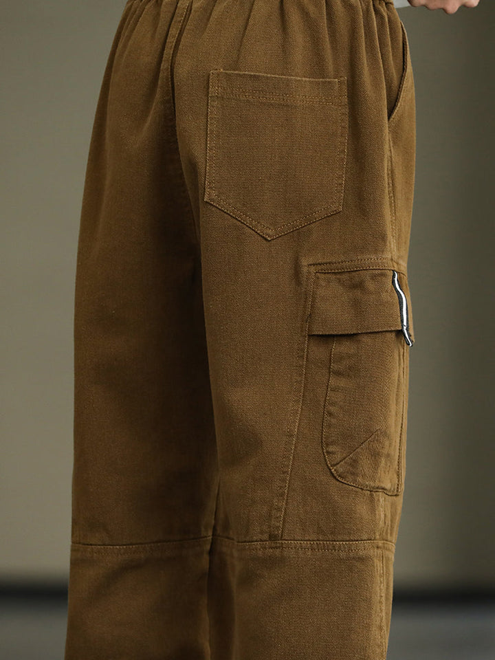 Un gros plan sur une poche de pantalon cargo ample resserré aux chevilles - Marron - Homme de Cargo District. Mélange de coton et viscose pour douceur et confort. Poches cargo latérales fonctionnelles. Tailles disponibles du M au 8XL.