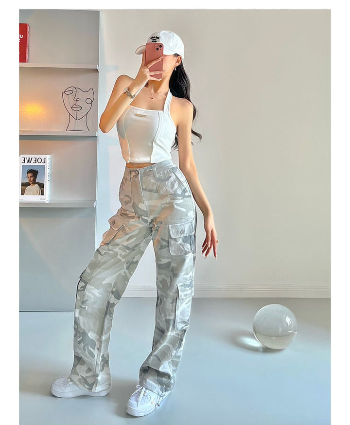 Une femme prenant un selfie avec un pantalon cargo taille haute à motifs gris camo. Les jambes larges peuvent être resserrées à la cheville. Disponible du M au 3XL. Confortable et tendance.