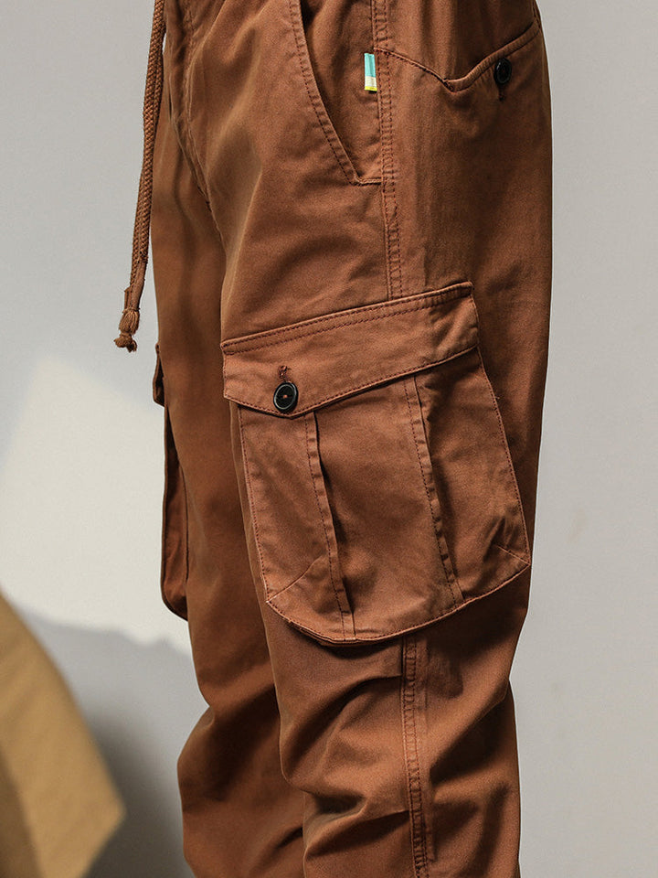 Un pantalon cargo coupe droite avec poches à bouton - Camel - Homme. Poches à rabats équipées d'un bouton apparent pour une fermeture sécurisée. Bas resserré aux chevilles. Tailles US 28 à 38.