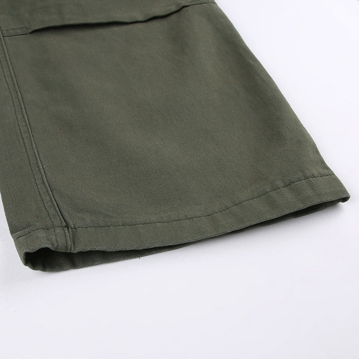 Un gros plan sur un pantalon cargo vert kaki pour femme avec des lanières autour des cuisses. Un look urbain audacieux avec une touche militaire. Disponible en tailles S à L.