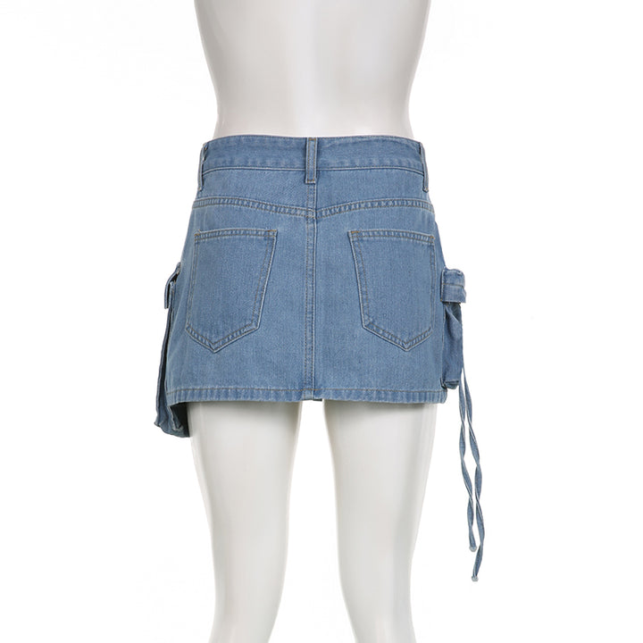 Une mannequin porte une jupe cargo en jean bleu avec plusieurs poches. Coupe droite, silhouette féminine et urbaine. Disponible du S au L.