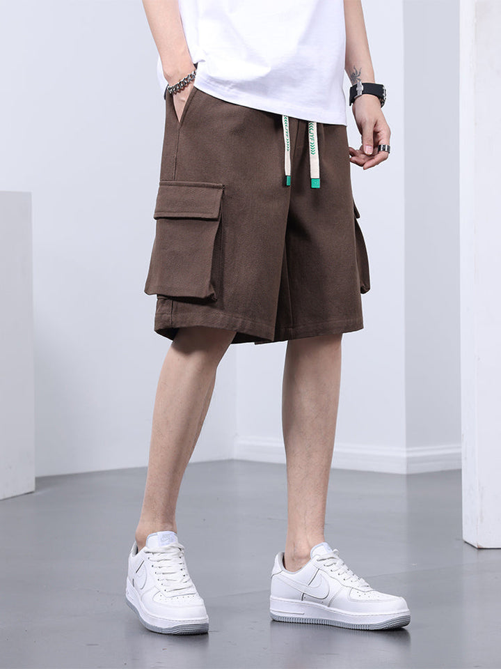 Un homme portant un short cargo marron clair, coupe large.