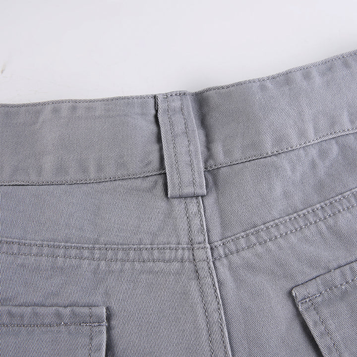 Un pantalon cargo ajusté flare gris pour femme avec des poches utilitaires. Taille haute et évasé en bas pour une silhouette féminine et tendance. Disponible du S au L.